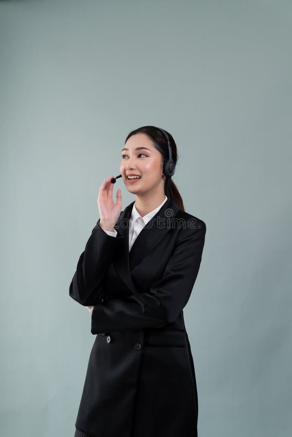 Attractive Asian operator with formal suit and headset. Enthusiastic stock images