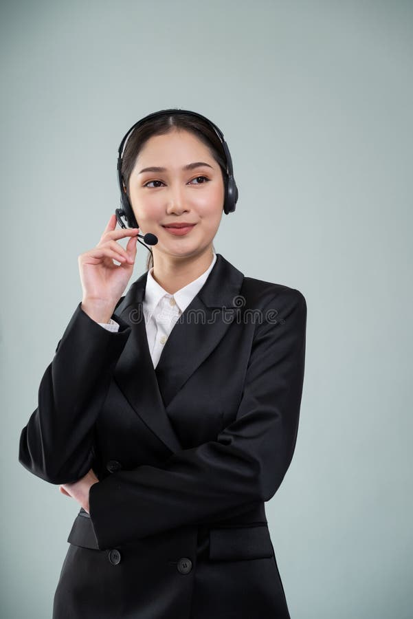 Attractive Asian operator with formal suit and headset. Enthusiastic stock photography
