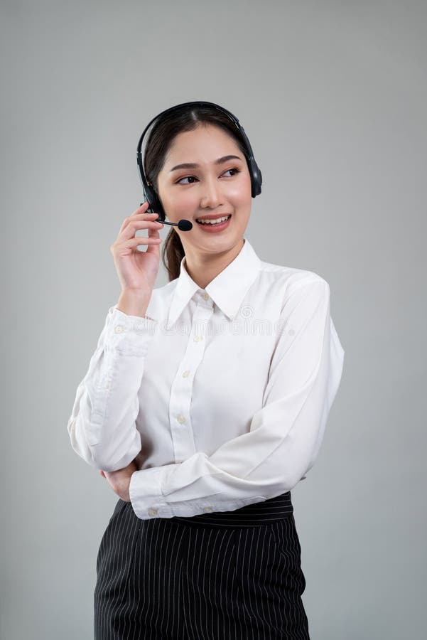 Attractive Asian operator with formal suit and headset. Enthusiastic stock photography