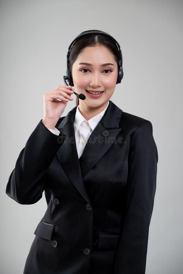 Attractive Asian operator with formal suit and headset. Enthusiastic royalty free stock photography