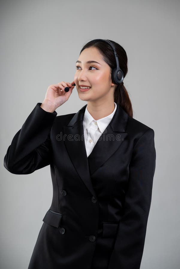 Attractive Asian operator with formal suit and headset. Enthusiastic royalty free stock photo