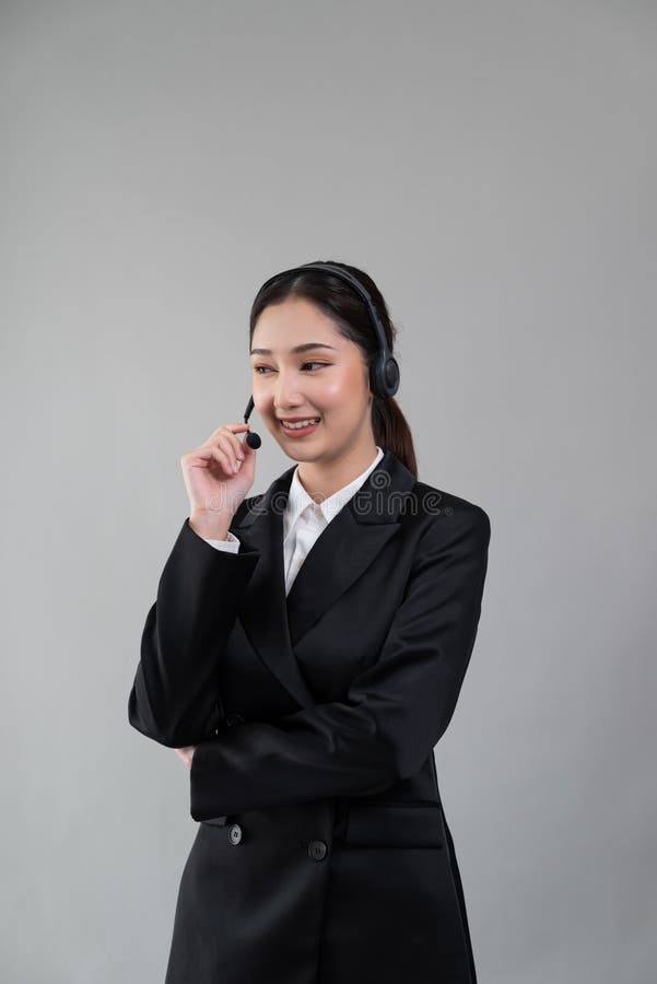 Attractive Asian operator with formal suit and headset. Enthusiastic royalty free stock image