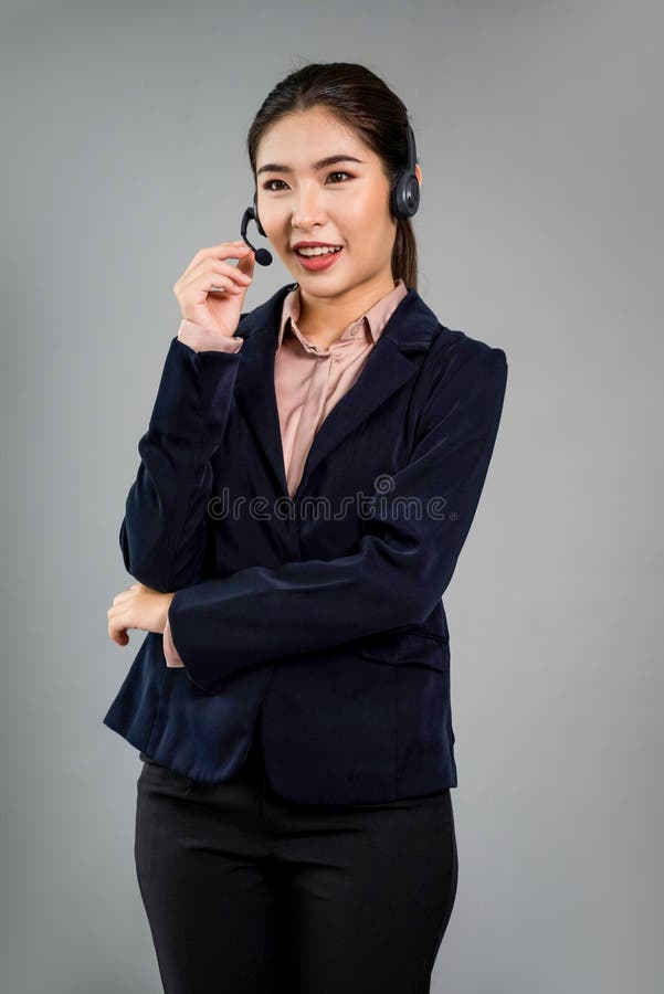 Attractive Asian operator with formal suit and headset. Enthusiastic royalty free stock photo