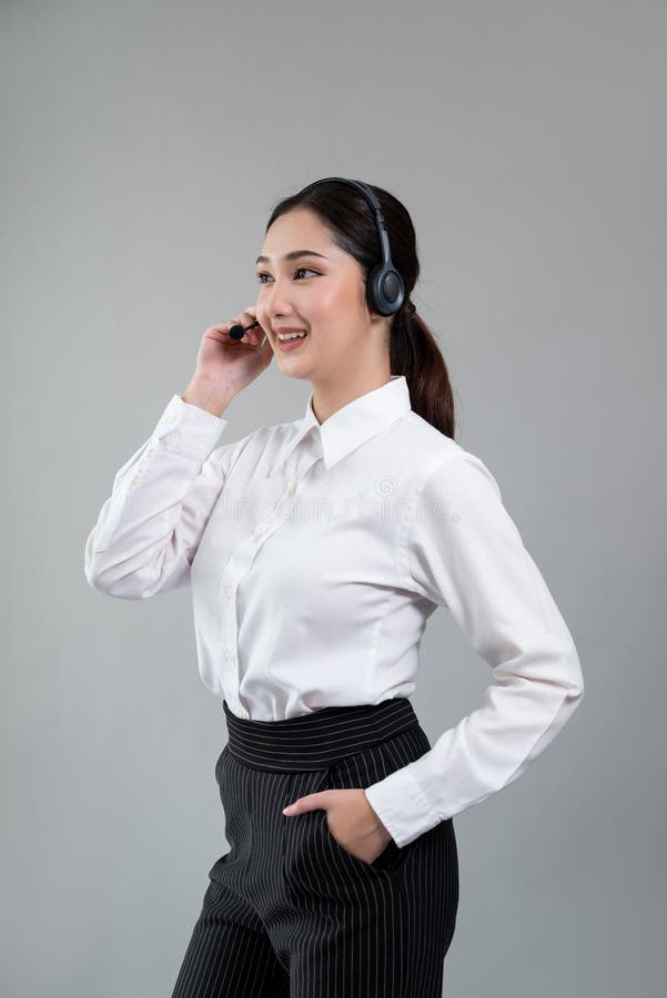 Attractive Asian operator with formal suit and headset. Enthusiastic royalty free stock photography