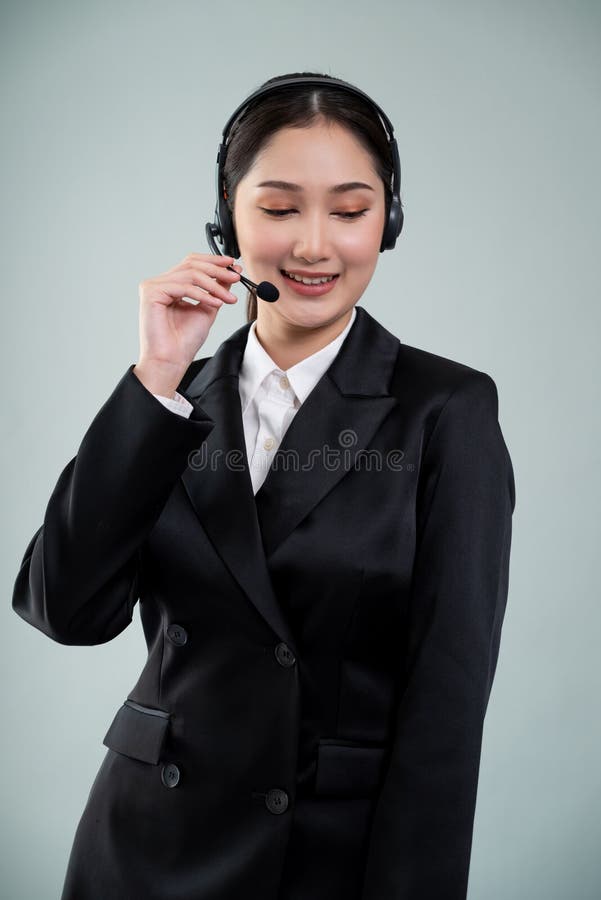 Attractive Asian operator with formal suit and headset. Enthusiastic royalty free stock image