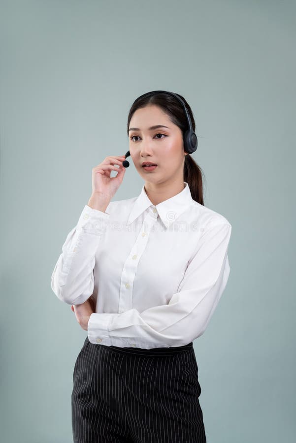 Attractive Asian operator with formal suit and headset. Enthusiastic stock photography