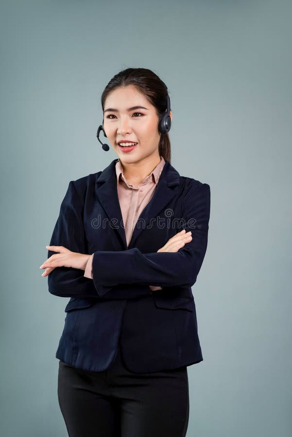 Attractive Asian operator with formal suit and headset. Enthusiastic stock photo