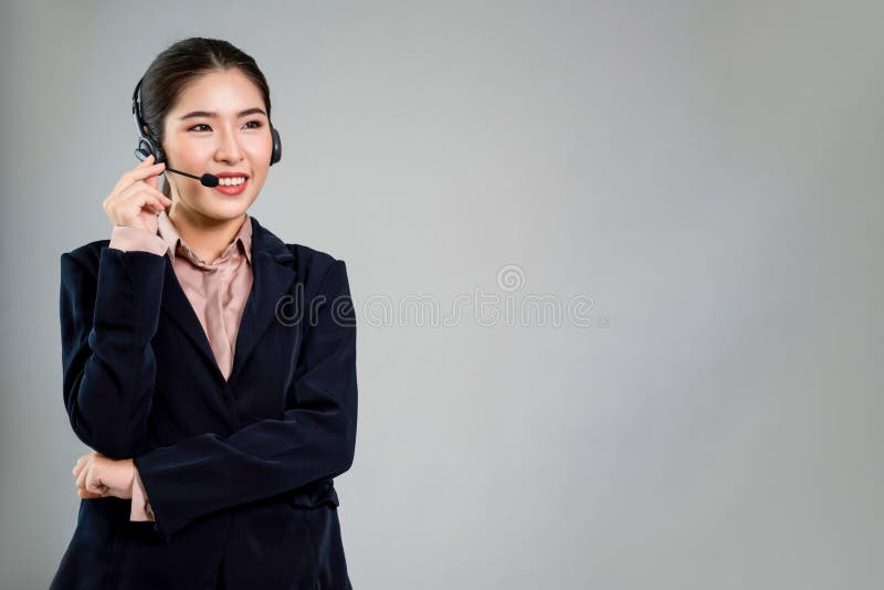 Attractive Asian operator with formal suit and headset. Enthusiastic stock images