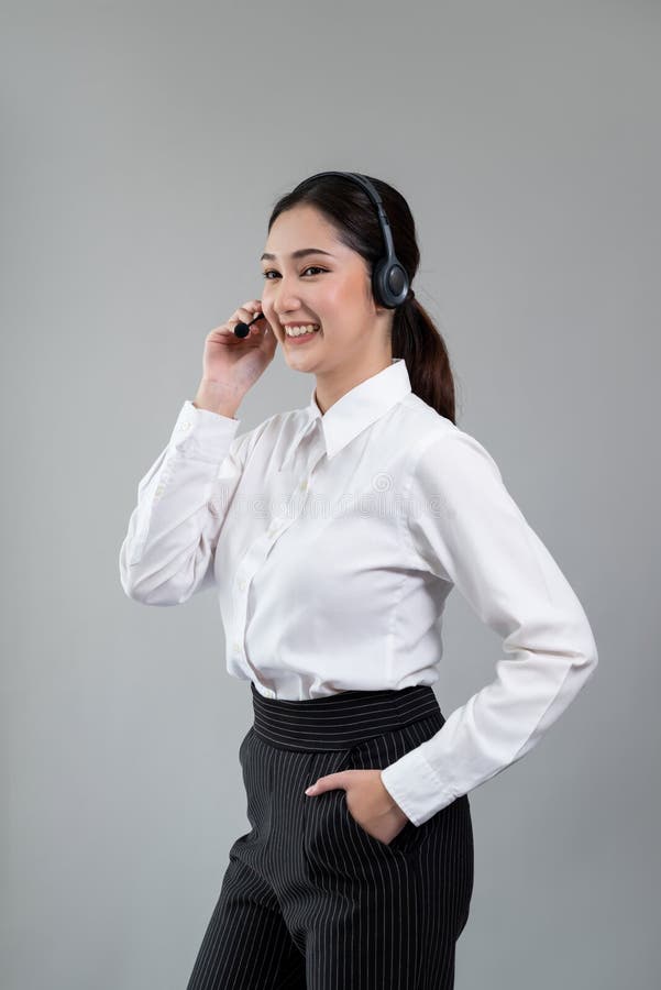 Attractive Asian operator with formal suit and headset. Enthusiastic royalty free stock image