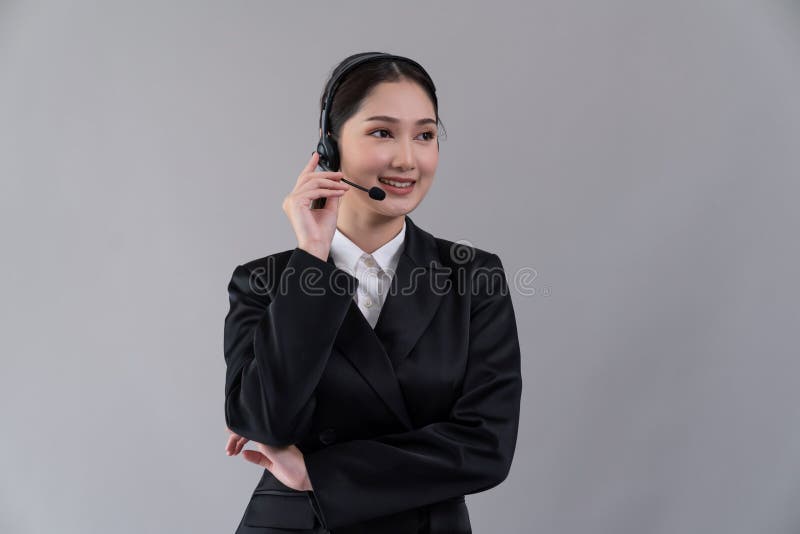 Attractive Asian operator with formal suit and headset. Enthusiastic royalty free stock photography