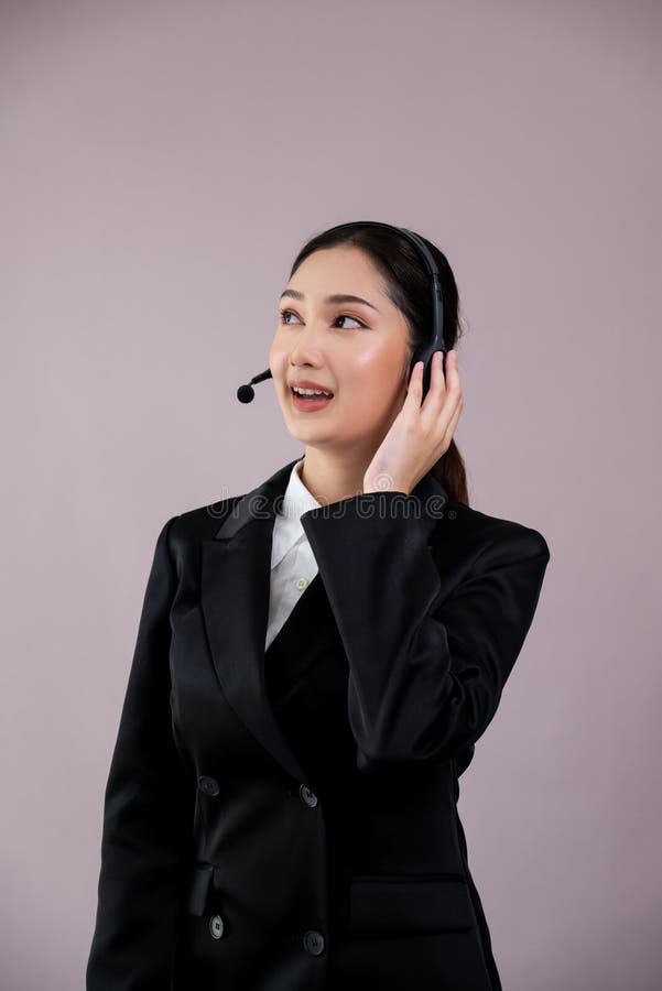 Attractive Asian operator with formal suit and headset. Enthusiastic royalty free stock photo