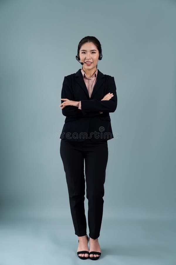 Attractive Asian operator with formal suit and headset. Enthusiastic royalty free stock image
