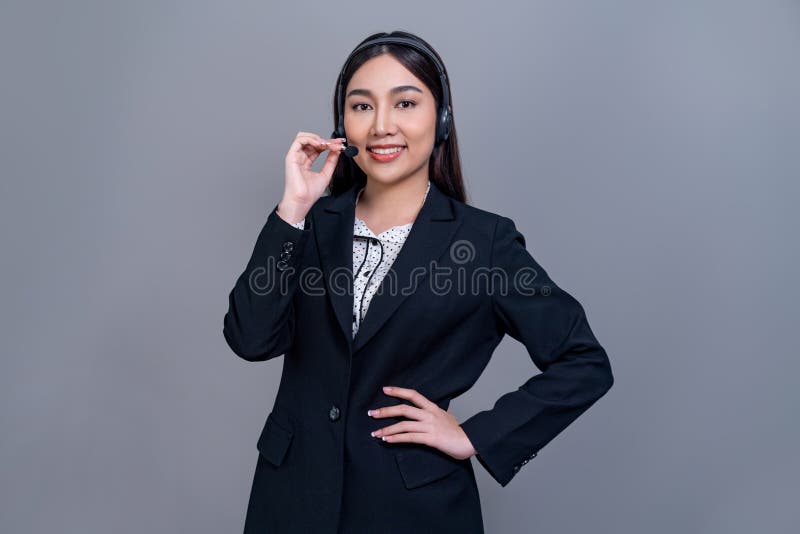 Attractive Asian operator with formal suit and headset. Jubilant royalty free stock photo