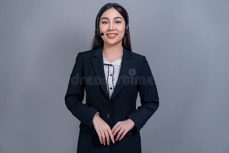 Attractive Asian operator with formal suit and headset. Jubilant royalty free stock image