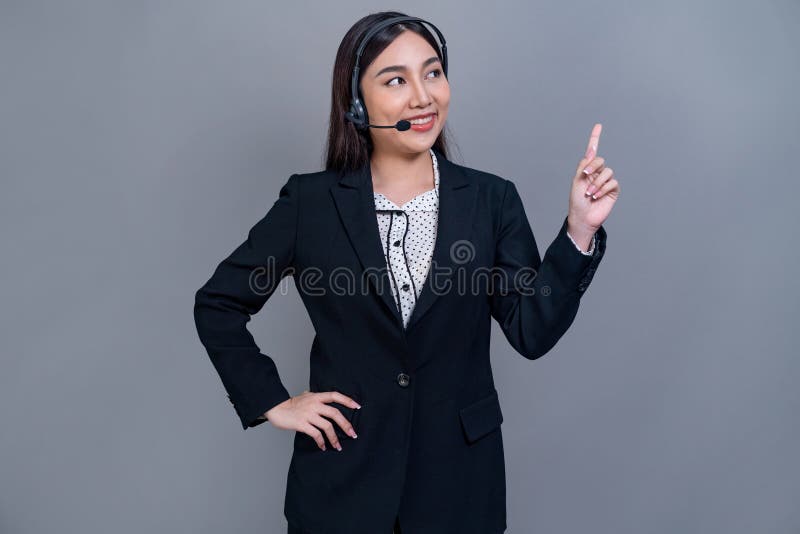 Attractive Asian operator with formal suit and headset. Jubilant stock image