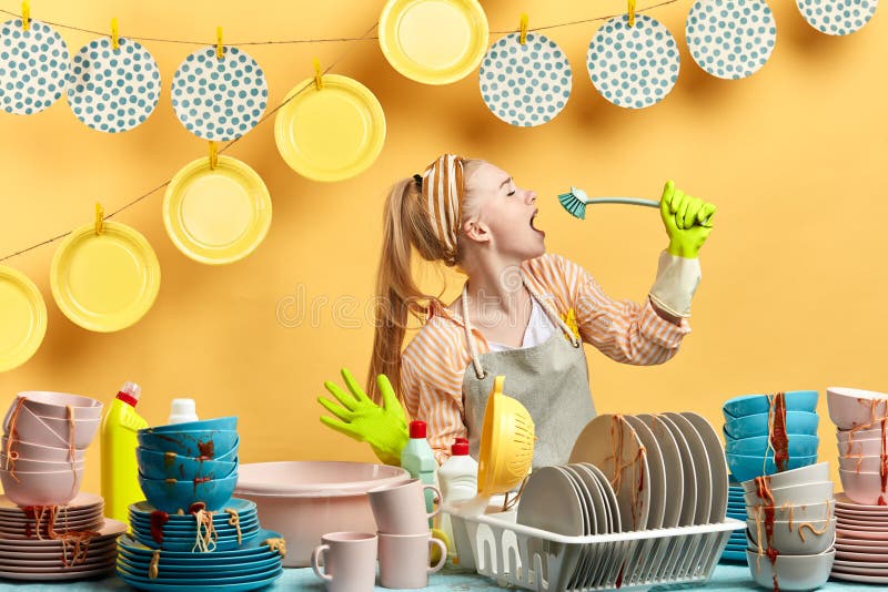 Attractive awesome girl in gray apron using brush as a microphone royalty free stock photos Attractive awesome girl in gray apron using brush as a microphone royalty free stock photos