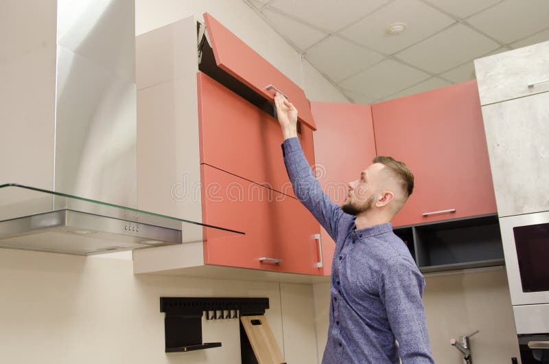 Attractive Bearded Man Opens the Top Drawer in a Modern Kitchen