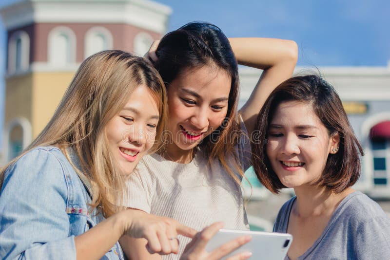 Attractive beautiful asian friends women using a smartphone. Happy young asian teenage at urban city while taking self portraits. stock photos Attractive beautiful asian friends women using a smartphone. Happy young asian teenage at urban city while taking self portraits. stock photos
