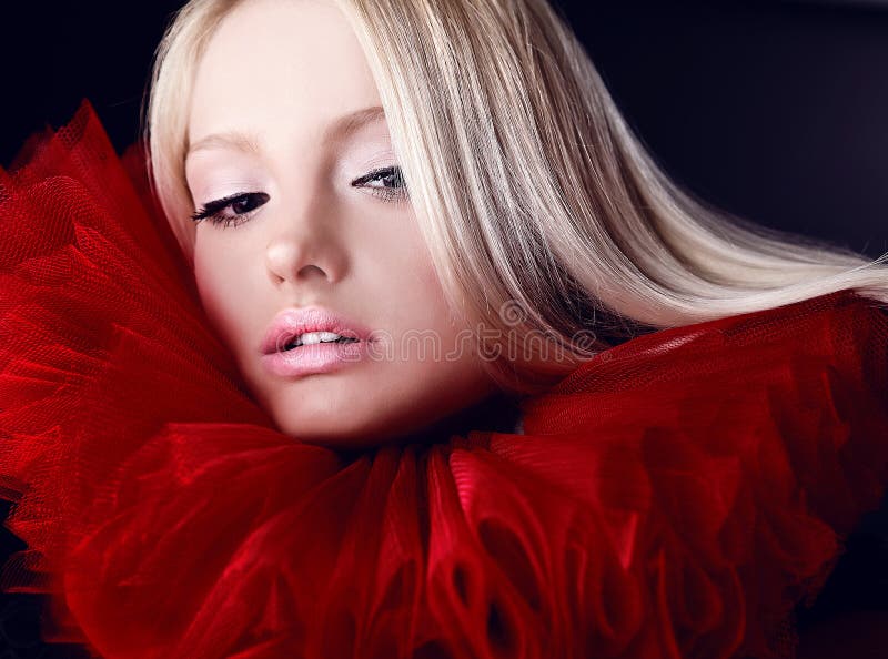 Attractive blond beauty in red theatrical jabot