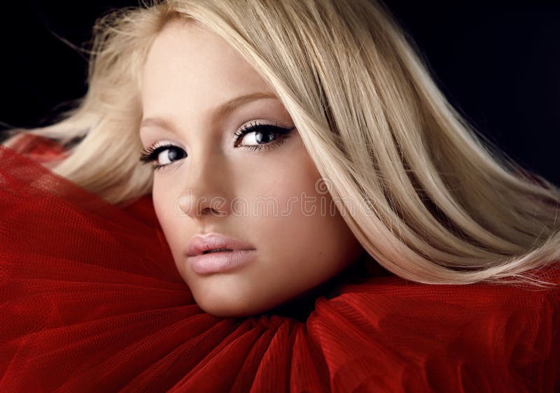 Attractive blond beauty in red theatrical jabot