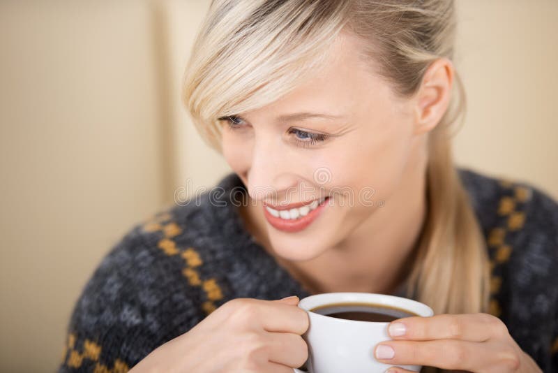 Attractive blond woman enjoying her cup of coffee royalty free stock photo