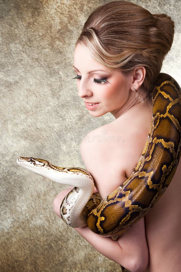 Attractive blond woman with python on grey