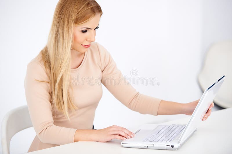 Attractive blond woman working on a laptop royalty free stock photography Attractive blond woman working on a laptop royalty free stock photography