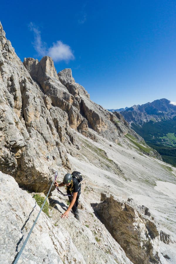 Attraente bionda una donna montagna alpinista sul ripido Attraverso più alto.