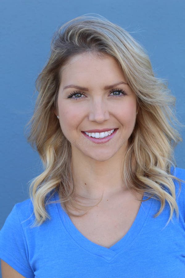 Attractive blonde woman smiling. Female portrait on blue background.