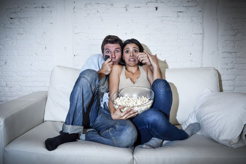 Attractive couple having fun at home enjoying watching television horror movie show royalty free stock image Attractive couple having fun at home enjoying watching television horror movie show royalty free stock image