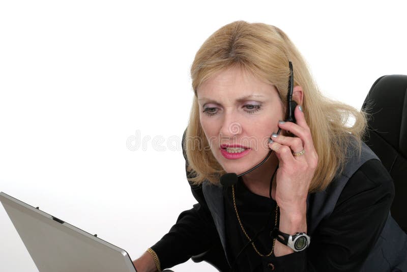 Attractive, smiling, customer service operator representative working at a computer with telephone headset. Attractive, smiling, customer service operator representative working at a computer with telephone headset