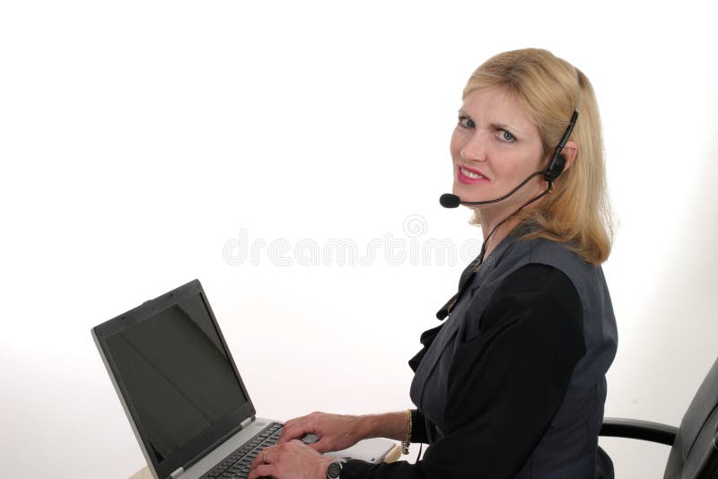 Attractive, smiling, customer service operator representative working at a computer with telephone headset. Attractive, smiling, customer service operator representative working at a computer with telephone headset