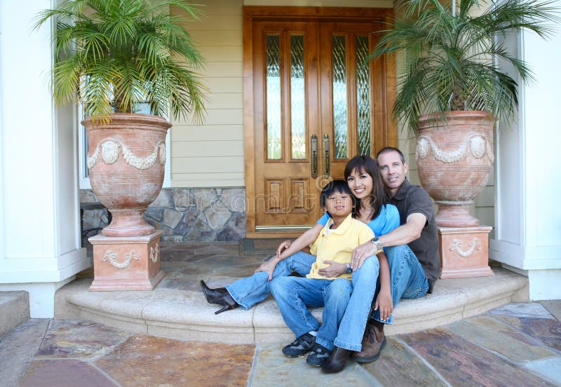 Attractive diverse family outside their home on porch. Attractive diverse family outside their home on porch