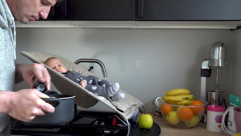 Father cooking while his cute baby boy is watching