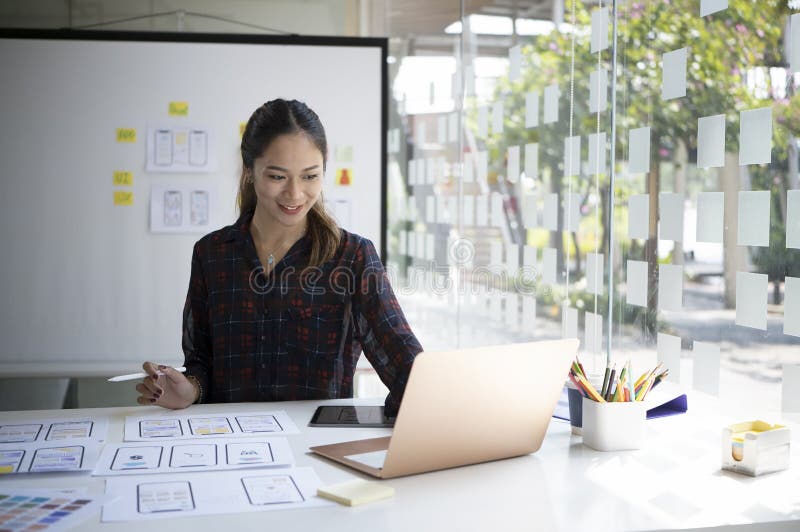 Female Designer Working on Mobile App Development at Modern Workplace