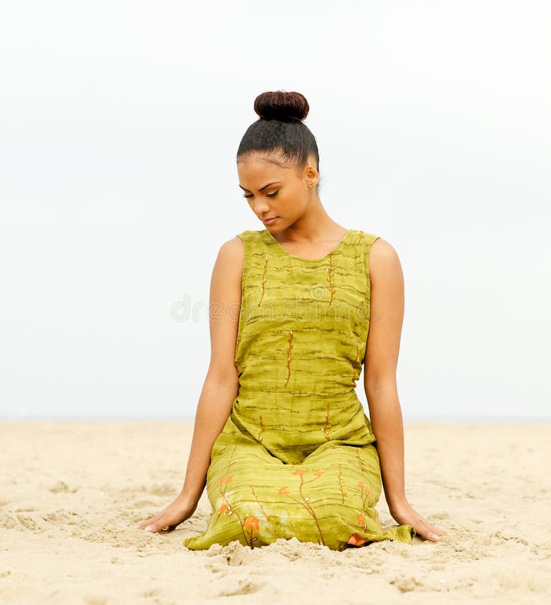 Attractive female sitting at the beach and meditating. Portrait of an attractive female sitting at the beach and meditating royalty free stock images Attractive female sitting at the beach and meditating. Portrait of an attractive female sitting at the beach and meditating royalty free stock images