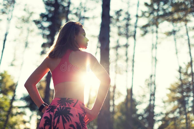 Attractive fit athletic woman in a forest, wearing smart watch, taking a break from intense workout. Sport, fitness, workout stock image Attractive fit athletic woman in a forest, wearing smart watch, taking a break from intense workout. Sport, fitness, workout stock image