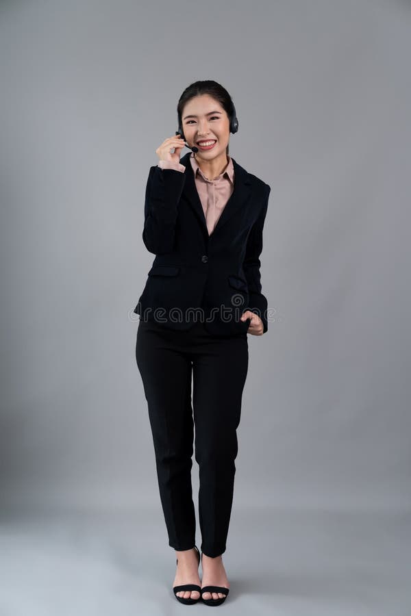 Attractive Asian operator with formal suit and headset. Enthusiastic stock photos