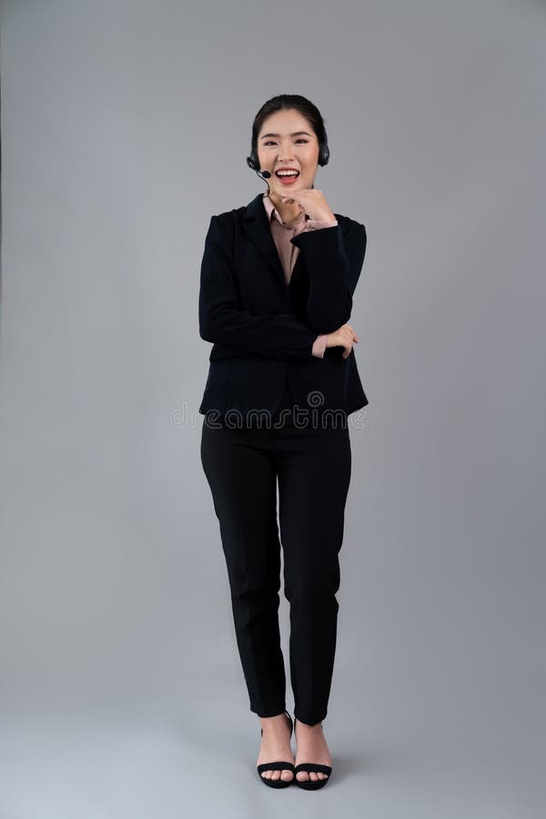 Attractive Asian operator with formal suit and headset. Enthusiastic royalty free stock images