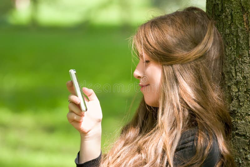 Attractive girl with phone in park