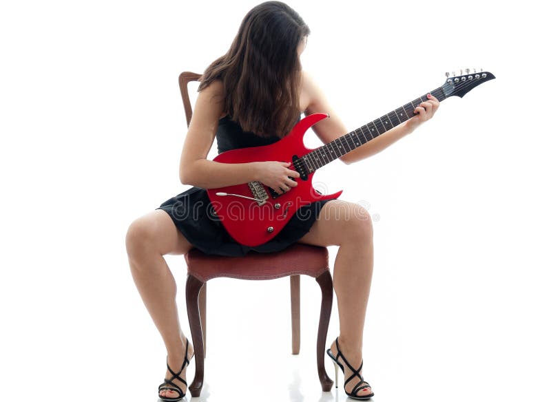 Attractive girl with red guitar sitting on a chair