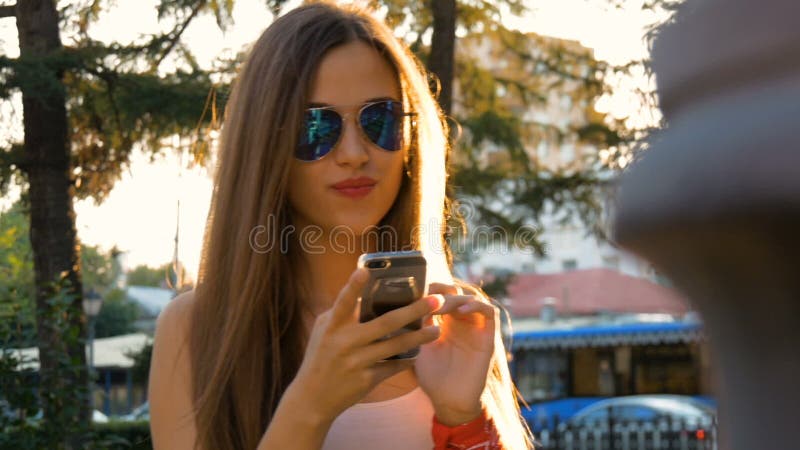 Attractive girl using mobile phone in a city.