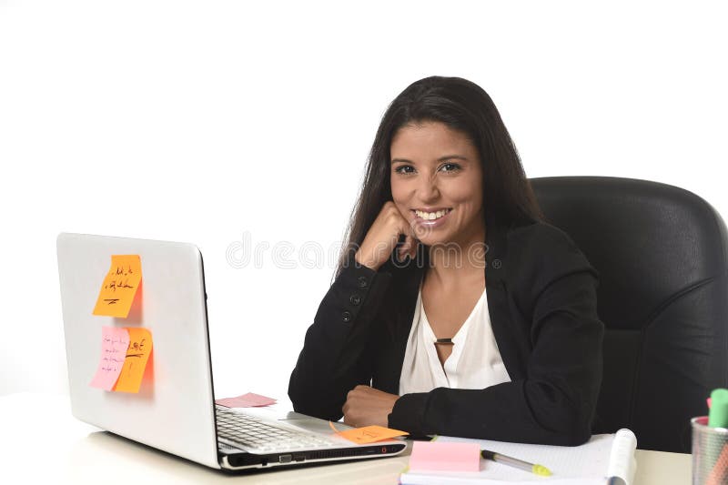 Attractive hispanic businesswoman sitting at office desk working on computer laptop smiling happy