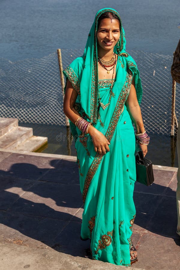 attractive indian woman in local sari, dressed for a festival enjoys posing for the photographer