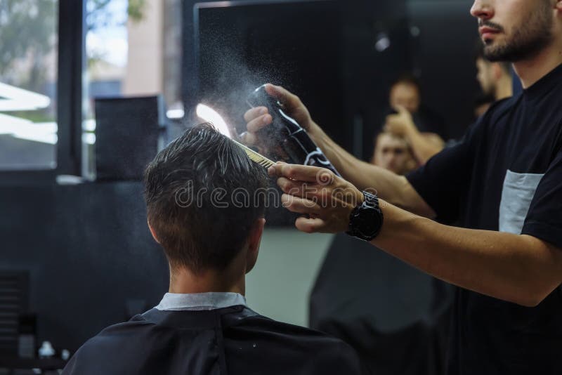 Attractive Male is Getting a Modern Haircut in Barber Shop. Barber Wets Hair  by Spray and Combs Them. Stock Image - Image of body, hairdresser: 153986857