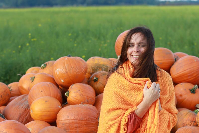 Attractive mature woman with orange pumpkins in autumn royalty free stock image Attractive mature woman with orange pumpkins in autumn royalty free stock image