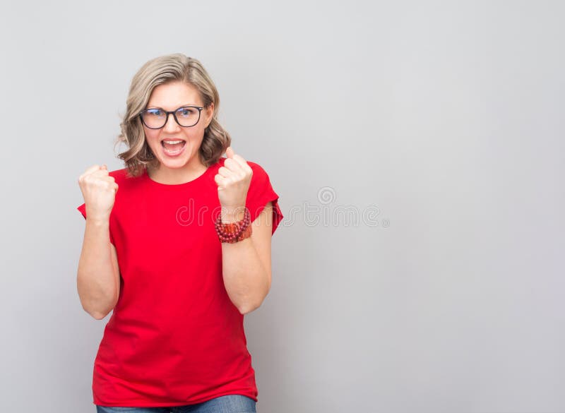 Attractive middle aged woman very happy and excited doing winner gesture with arms raised, smiling and screaming for success. Winner and celebration concept. Attractive middle aged woman very happy and excited doing winner gesture with arms raised, smiling and screaming for success. Winner and celebration concept