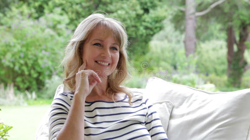 Attractive Middle Aged Woman Sitting Outdoors And Smiling