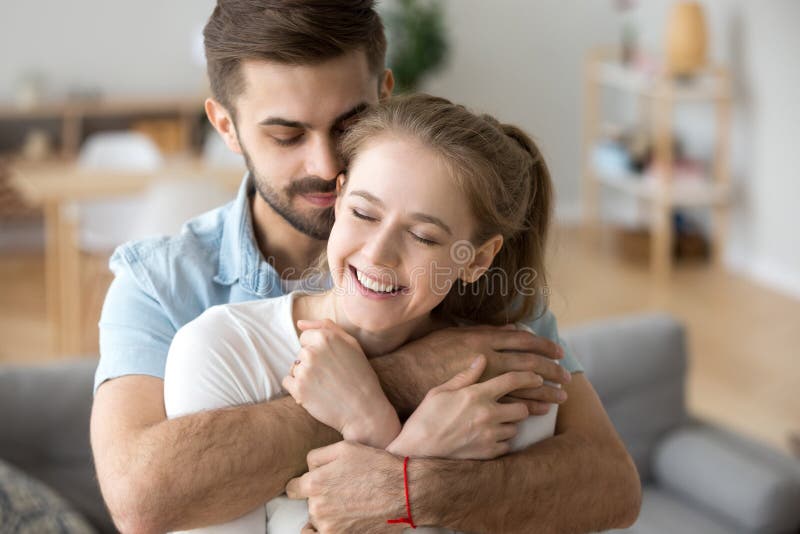 Attractive Millennial Happy Married Couple Embracing Indoors Stock Image