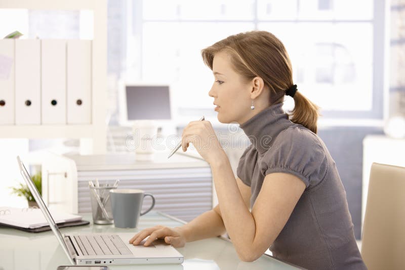 Attractive office worker sitting at desk stock photography Attractive office worker sitting at desk stock photography